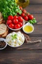 Italian food ingredients Ã¢â¬â mozzarella, tomatoes, basil and olive oil on rustic wooden table. Royalty Free Stock Photo